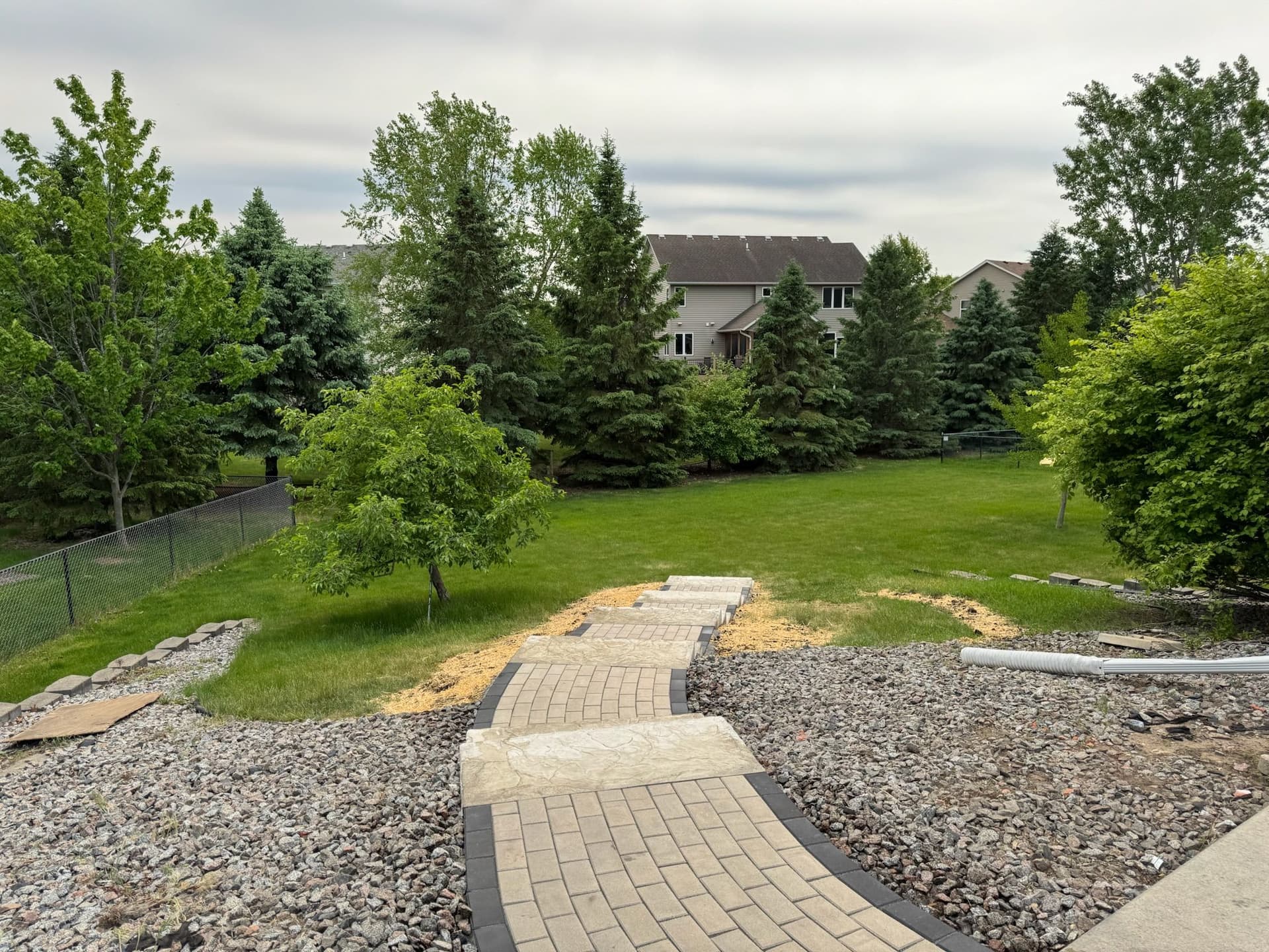 Paver Pathway and Staircase Built Down a Sloped Backyard image